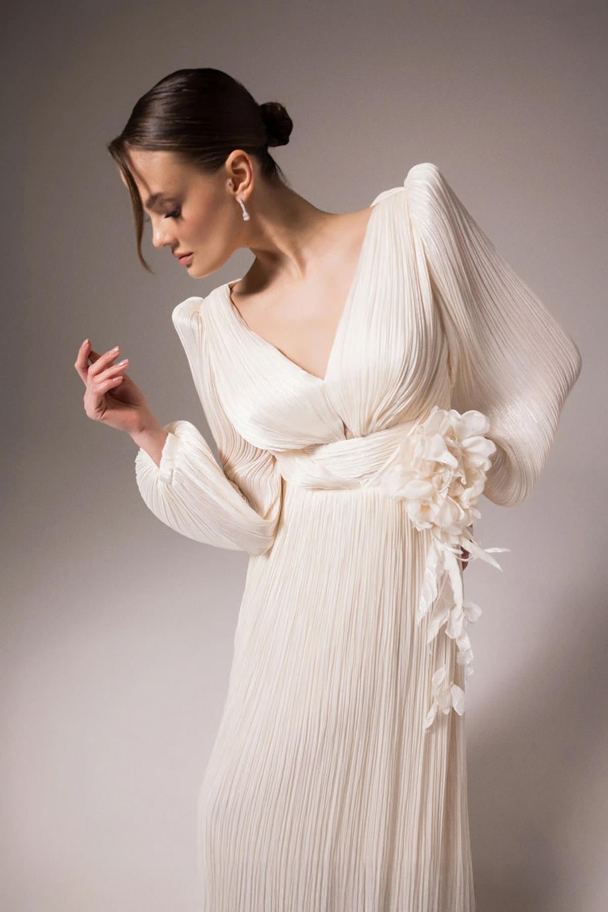 فستان سهرة واسع بفتحة رقبة على شكل حرف V وتصميم زهور على الخصر وتفاصيل نافذة خلفية