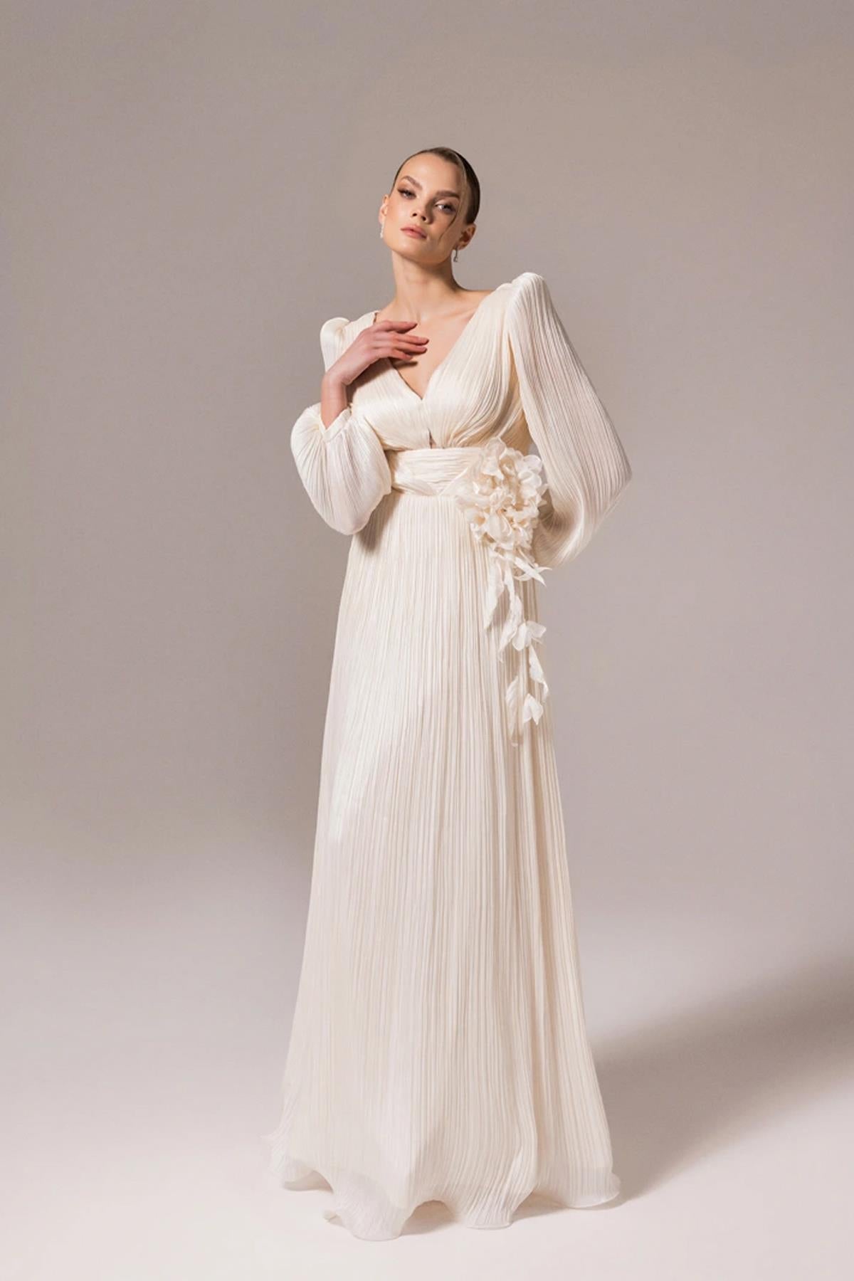 فستان سهرة واسع بفتحة رقبة على شكل حرف V وتصميم زهور على الخصر وتفاصيل نافذة خلفية